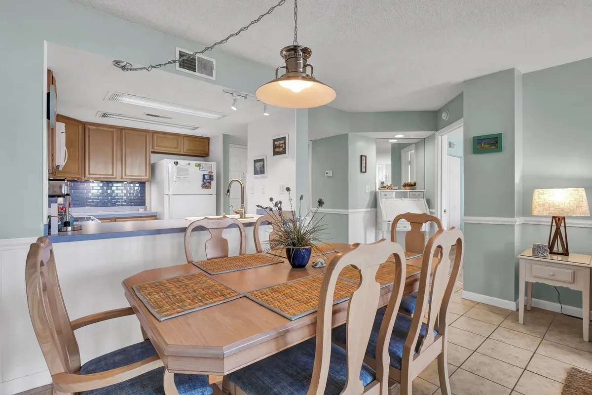 A warm, welcoming dining area centered around a spacious dining table with comfortable seating and a softly glowing lighting fixture. Decorative accents and a well-set table evoke a sense of togetherness and ease.